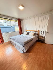a bedroom with a bed and a wooden floor at Casa Cypresses in Temuco