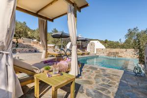 a patio with a couch and a table next to a pool at Luxury VILLA RAFAEL in Skopelos Town
