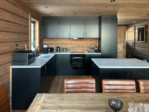 a kitchen with blue cabinets and a wooden wall at Mountain Lodge With Views Over Idre in Idre
