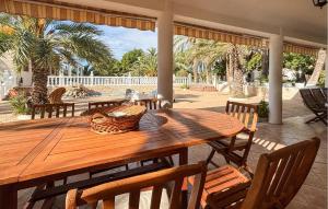 a wooden table with chairs and a basket on a patio at Lovely Home In Elda With Private Swimming Pool, Can Be Inside Or Outside in Almafrá