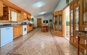a large kitchen with wooden cabinets and a table at Pet Friendly Home In Elda in Almafrá