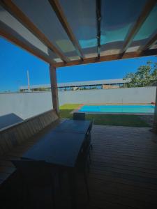 a patio with a table and a swimming pool at Sua casa em pdetorres in Passo De Torres +24 photos