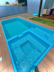 a large blue swimming pool with water in it at Sua casa em pdetorres in Passo De Torres