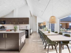a kitchen with long tables and chairs in a room at 5 star holiday home in Bogense in Bogense
