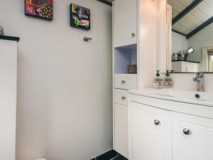 een badkamer met een wastafel en een spiegel bij Secluded Haven in Rindby in Fanø +29 foto's