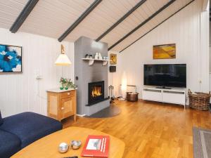 een woonkamer met open haard en tv bij Secluded Haven in Rindby in Fanø