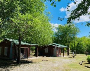 a log cabin with a tree in front of it at Cabañas Esmeralda in Villa Ciudad de America