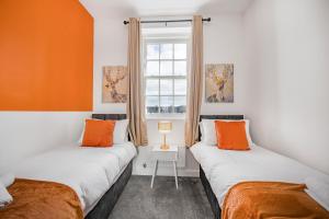 WrittleにあるGrace Bartlett House for 5 with Free Parking for 2のオレンジと白の壁の客室で、ベッド2台が備わります。