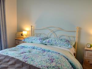 a bed with a blue headboard and pillows on it at The Blue Loft in Rye