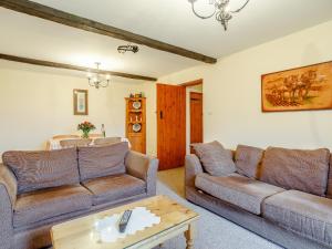 a living room with two couches and a table at Rafters Barn - E2064A in Runcton Holme