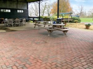 a picnic table and bench on a brick patio at Heron in Welney