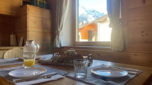 a wooden table with two plates and a glass of orange juice at Appartamento vista Baranci in San Candido