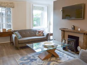 een woonkamer met een bank en een open haard bij Prudhoe Mews in Alnmouth