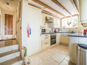 a kitchen with white cabinets and a window at Tir A Mor in Nefyn