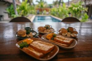 a wooden table with plates of sandwiches and biscuits at TALI BOUTIQUE Hotel in Ao Nang Beach