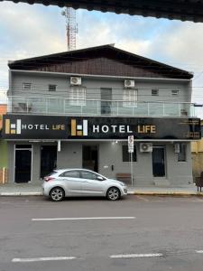 a silver car parked in front of a hotel life at Hotel Life Ijui in Ijuí