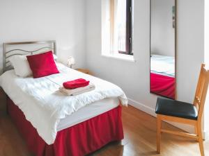 une chambre avec un lit avec un miroir et une chaise dans l'établissement Russet Cottage - E4678, à Lympsham