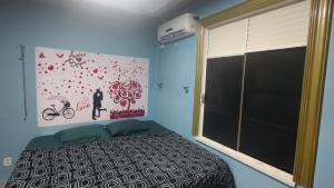 ein Schlafzimmer mit einem Bett und einem großen Fenster in der Unterkunft Quarto Suíte Parque Dez in Manaus