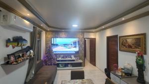 ein Wohnzimmer mit einem Weihnachtsbaum und einem TV in der Unterkunft Quarto Suíte Parque Dez in Manaus