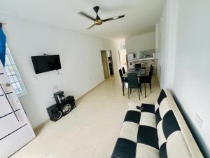 a living room with a couch and a ceiling fan at Apto con piscina a 7 min caminando de playa Bello Horizonte in Santa Marta