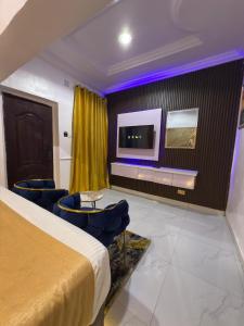 a hotel room with a bed and a tv at Palazzo Apartments in Ikeja