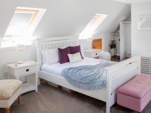 1 Schlafzimmer mit einem weißen Bett und 2 Fenstern in der Unterkunft Rose Cottage in Dingwall