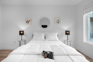 een witte slaapkamer met een wit bed met een handtas erop bij Luxury 1br Getaway - Modern Stylish & Great Area in Philadelphia