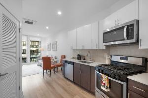 een keuken met witte kasten en een kookplaat oven bij Luxury 1br Getaway - Modern Stylish & Great Area in Philadelphia