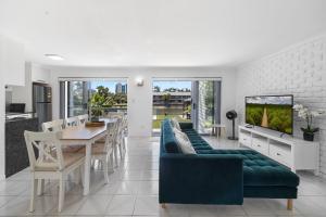 a living room with a dining table and a tv at 4 bedroom fabulous home on canal in Mooloolaba