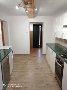 a kitchen with white cabinets and green counter tops at Noclegi W Sadzie in Rajcza