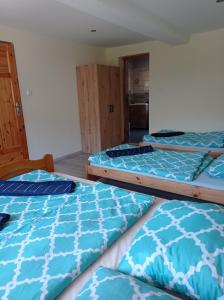 a group of three beds in a room at Noclegi W Sadzie in Rajcza