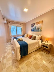 a bedroom with a large bed and a window at Apto 2 dorm Centro de Capão 3 quadras do Mar box e churrasqueira in Capão da Canoa