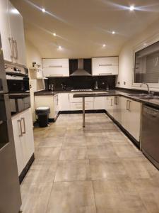 une grande cuisine avec des placards blancs et une table. dans l'établissement Velora 4 BR Villa With pool and waterfall in New Cairo, au Caire