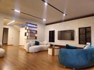 un salon avec deux canapés et une télévision dans l'établissement Velora 4 BR Villa With pool and waterfall in New Cairo, au Caire