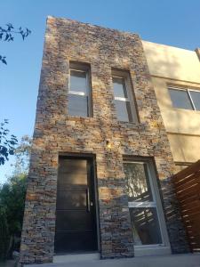 a brick building with a black door and windows at Duplex en City Bell in City Bell