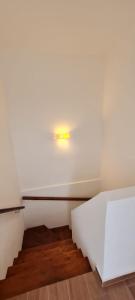 a white room with a staircase with a light on the wall at Duplex en City Bell in City Bell