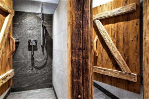a bathroom with a shower with a wooden wall at Vordersattlegghofhütte in Hüttau
