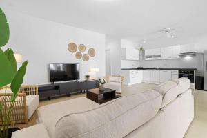 a living room with a couch and a tv at The Shores 3 with sea views beautiful sunsets and a breezy balcony in Kralendijk