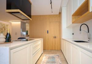 a kitchen with white cabinets and a sink at Apartament Modern in Kosovo Polje +5 photos
