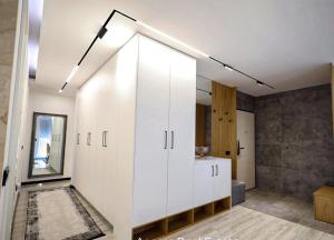 a bathroom with white cabinets and a mirror at Apartament Modern in Kosovo Polje