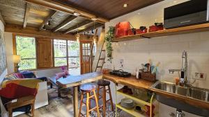 een keuken met een wastafel en een aanrecht met krukken bij Le Ville - Chalé 1 in Campos do Jordão +29 foto's