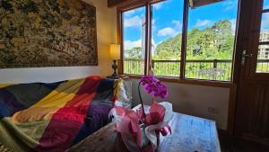 een kamer met een tafel met bloemen erop bij Le Ville - Chalé 1 in Campos do Jordão