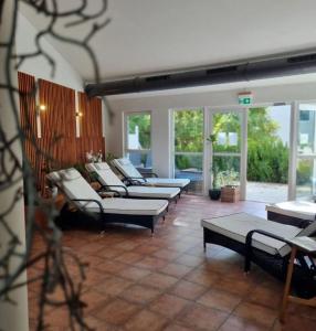 Una habitación con varios sofás, mesas y ventanas. en Design-Apartment am Plöner See, en Ascheberg