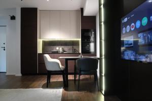 a kitchen with a table and two chairs and a tv at Four Collection in Prishtinë