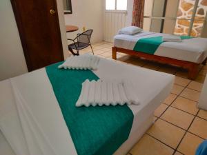 a room with two beds and a table with a bedskirts at Ameyali Teques in Tequesquitengo +44 photos