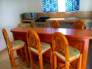 a kitchen with a wooden table with chairs and a sink at Ameyali Teques in Tequesquitengo