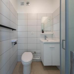 a white bathroom with a toilet and a sink at Cénoslocs Aulnay for 6-7 people close to CDG in Aulnay-sous-Bois