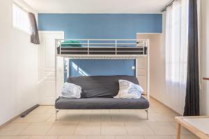 a bed in a room with a bunk bed at Cénoslocs Aulnay for 6-7 people close to CDG in Aulnay-sous-Bois