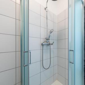 a shower in a bathroom with a glass door at Cénoslocs Aulnay for 6-7 people close to CDG in Aulnay-sous-Bois