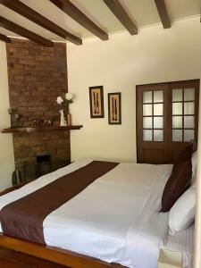 西隆Mid Hill Cottage Guest Suites Nongrim的卧室设有一张大床,配有壁炉